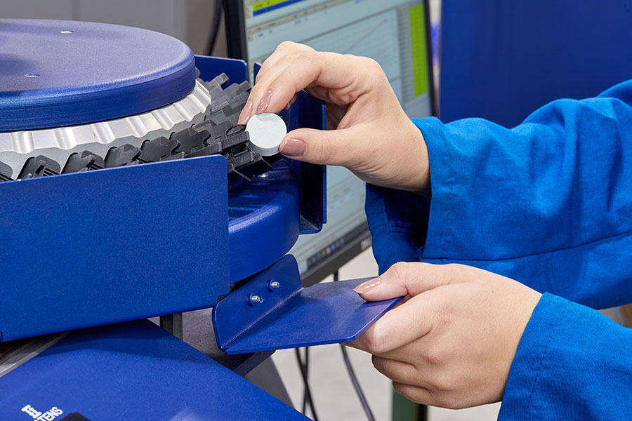 Engineer feeding samples into samples automation system on a Premier RPA from Alpha Technologies